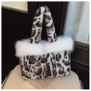 Detail shot of leopard print faux fur tote bag with fluffy white plush edges on a chair