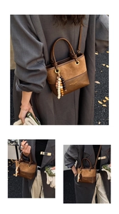 Détail d'un sac seau vintage marron avec charm perlé dans un décor d'automne