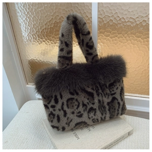 Detailed view of leopard print faux fur tote bag on a book in soft natural light