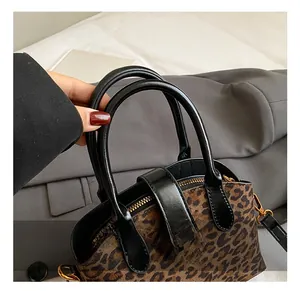 Detailansicht der Handtasche mit Leopardenmuster, goldener Schnalle und schwarzen Griffen