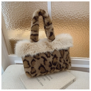 Close-up of leopard print faux fur tote bag with plush white trim on a book