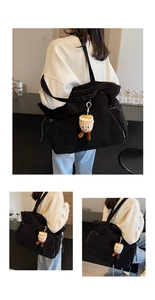 Dettaglio della borsa tote in velluto a coste nero con texture a coste e ciondolo a forma di caffè