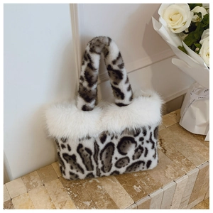 Detailed view of leopard print faux fur tote bag with white plush trim on marble background