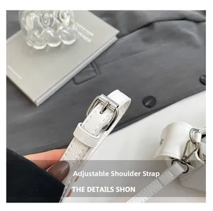 Detail of adjustable white lychee leather shoulder strap with silver buckle hardware