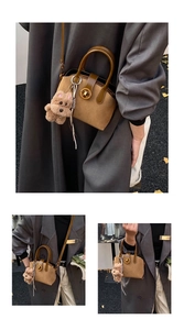 Details der Vintage-Handtasche mit grünen Griffen und süßem Plüsch-Hundeanhänger