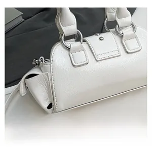 Close-up of white wrinkled leather texture and silver metal rings on the handbag