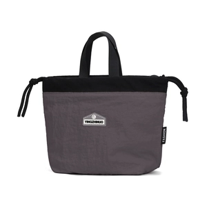 Detail of nylon drawstring bag showing grey and black patchwork and logo patch