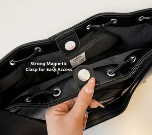 Détail de la fermeture magnétique et de l'ouverture à cordon du sac seau en cuir noir