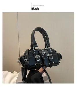 Detail of a black shiny patent leather handbag with silver buckles and adjustable strap