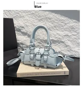 Detail view of light blue Y2K motorcycle bag with decorative buckles and silver rivets