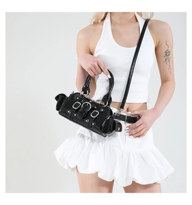 Detail of black glossy leather bag with silver metal buckles and punk rivets style