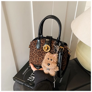 Detail der Boston-Tasche mit Leopardenmuster, goldenem Drehverschluss und Plüsch-Anhänger