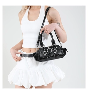 Detail of black punk motorcycle handbag with metal buckles and glossy texture on white background