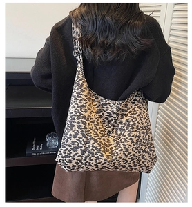 Close-up of a large leopard print canvas tote bag with adjustable black shoulder strap
