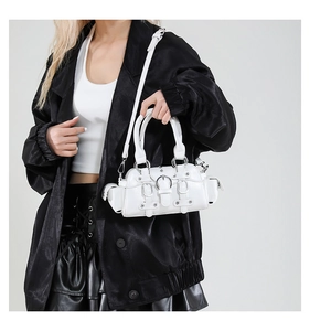 Detailed view of white punk biker handbag featuring silver buckles and rivet accents