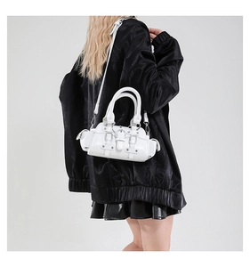 Close-up of white biker style handbag with silver rivets and metallic hardware detail