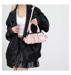 Detail of hot pink glossy Y2K handbag featuring metal buckles and multiple pockets