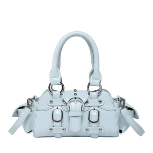 Close-up of light blue patent leather bag with silver rivets and metallic buckles