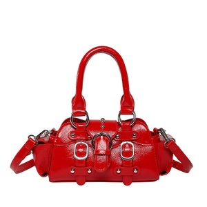 Detailed macro view of glossy red patent leather finish with silver metal buckle and rivets