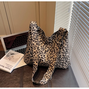 Close-up of leopard print canvas tote bag with adjustable strap in a modern lifestyle setting
