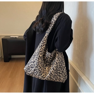 Chic leopard print tote bag with adjustable strap shown as a crossbody on a model