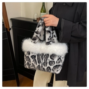 Close-up of fluffy black and white leopard print faux fur handbag with white plush trim