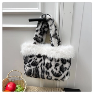 Detailed plush leopard print handbag hanging on a door with a cozy woven fruit basket
