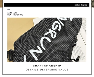 Detailansicht der schwarzen strukturierte Brusttasche mit großem weißem Buchstabenaufdruck