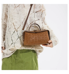 Close-up of leopard print crossbody bag with brown faux suede texture and top handle