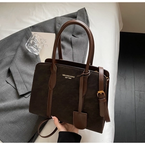 Detail der Vintage-Tote-Bag in Kaffeebraun mit Markenlogo und verstellbarem Schultergurt