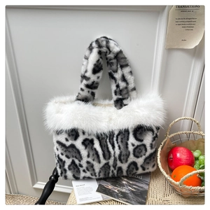 Detail of faux fur leopard print tote with fluffy white trim on a wicker chair