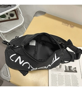 Detailansicht der schwarzen karierten Brusttasche mit Schnalle auf Vintage-Koffer