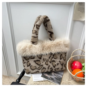 Close-up of leopard print faux fur tote bag with fluffy beige trim on a woven stool