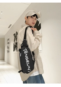 Detailaufnahme der schwarzen Brusttasche mit Karomuster und weißem künstlerischem Text