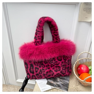 Detailed texture of rose red leopard print faux fur handbag with plush trim