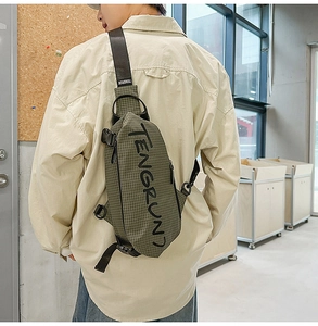 Detailansicht einer olivgrünen karierten Brusttasche mit verstellbarem Gurt am Model
