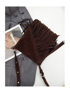 Close-up of dark brown suede tassel bucket bag with metallic ring and strap details