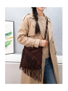Close-up of brown suede fringe crossbody bucket bag with bohemian tassel detail