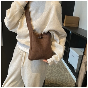 Détail du sac seau en maille marron foncé avec fermeture à bascule et bandoulière