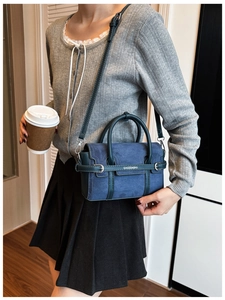Detail van de marineblauwe crossbodytas met matte suède textuur en verstelbare riem