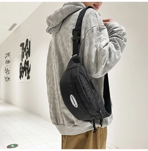 Detail view of the black plaid crossbody waist bag with adjustable strap and plastic buckle