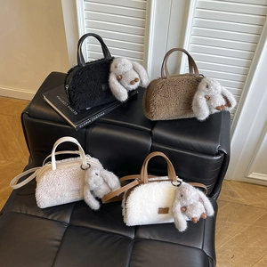 Detail view of four plush teddy tote bags with leather handles and rabbit pendants