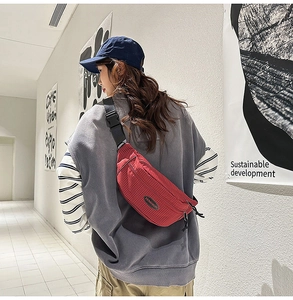 Rear view of red checkered crossbody bag showing adjustable strap and buckle on model