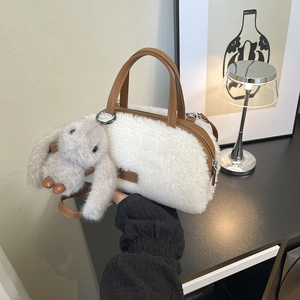 Detail of white faux fur handbag with brown leather handle and cute bunny pendant