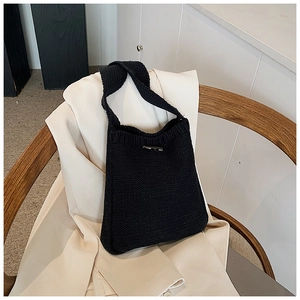 Vue détaillée d'un sac seau en tricot noir avec boucle en corne argentée sur veste