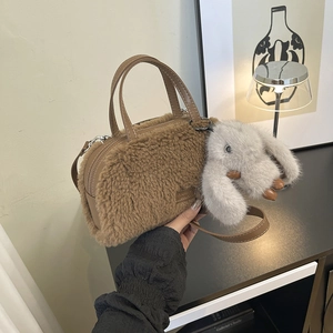 Detailed macro view of brown faux shearling box bag with plush texture and cute bunny charm