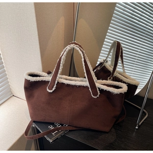 Détail du sac cabas en daim marron avec bordure en fausse fourrure blanche et anses