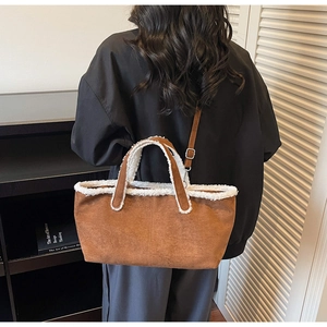 Détail du sac cabas en daim marron avec garnitures et poignées en peau de mouton blanc