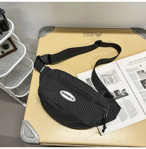 Detail showing black and white checkered crossbody bag with adjustable strap and logo