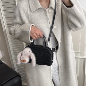 Black faux fur mini crossbody bag featuring a cute plush bunny doll charm for autumn style